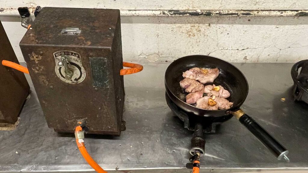 大沢温泉の台所で肉を焼いているところ